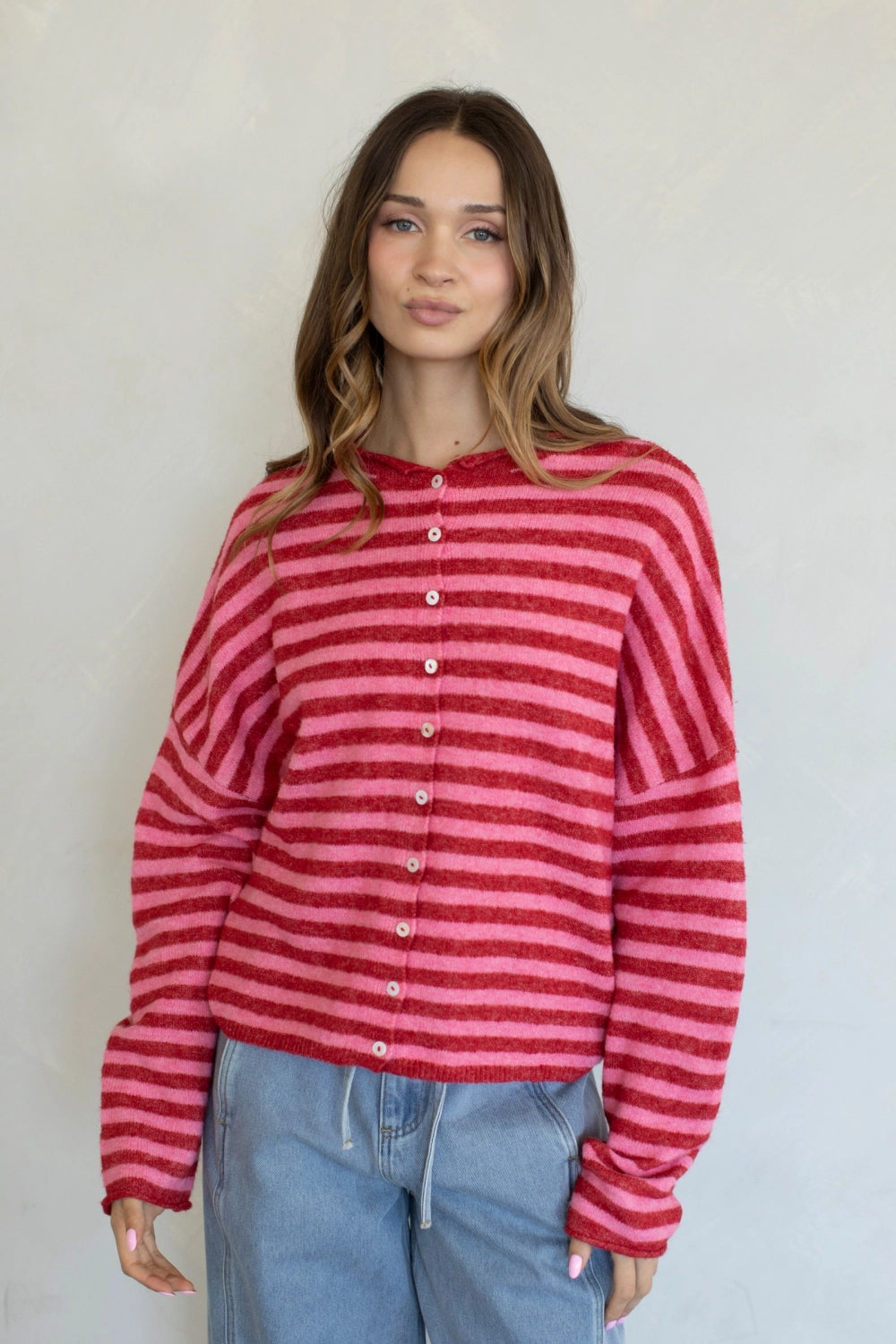 Front view of the Hailey Button Down Cardigan in a red and pink striped knit.