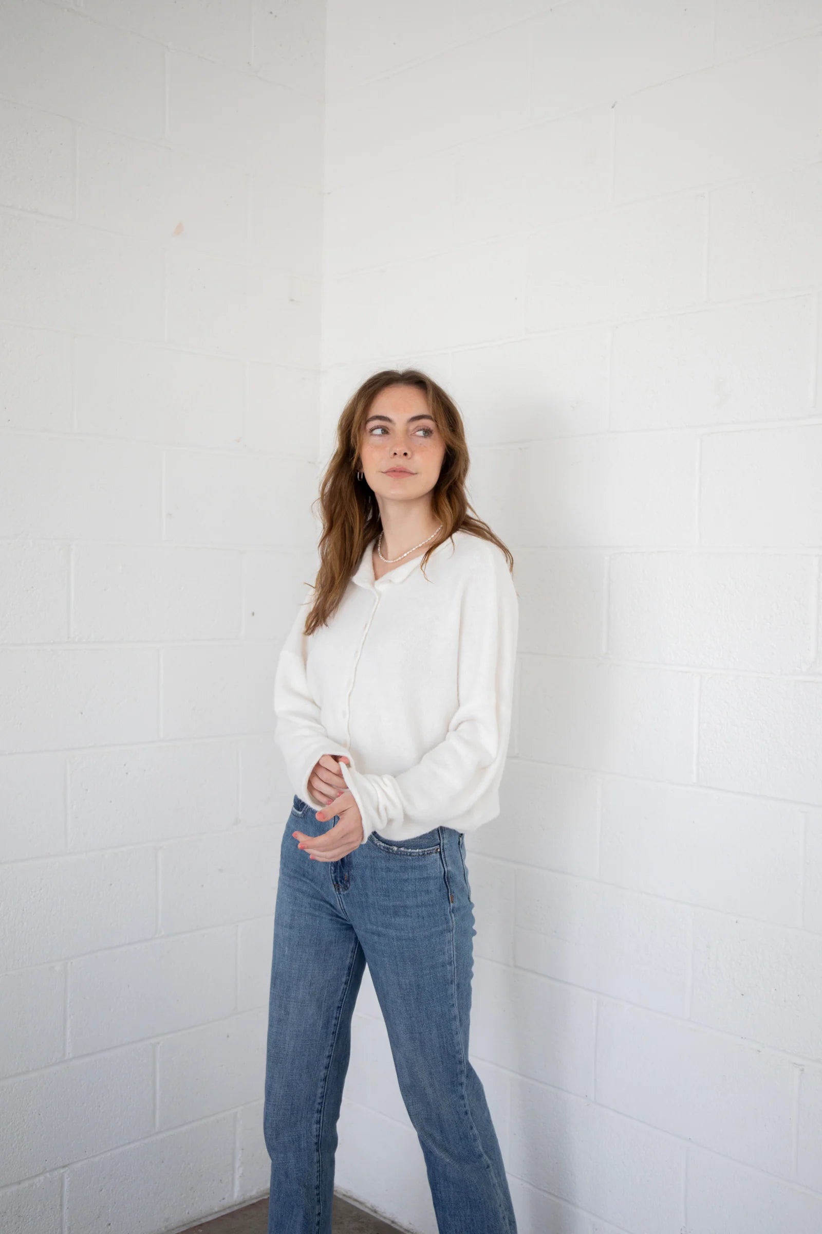 Woman is wearing the Hailey Button Down Cardigan (Piper Cardigan) in off-white paired with jeans