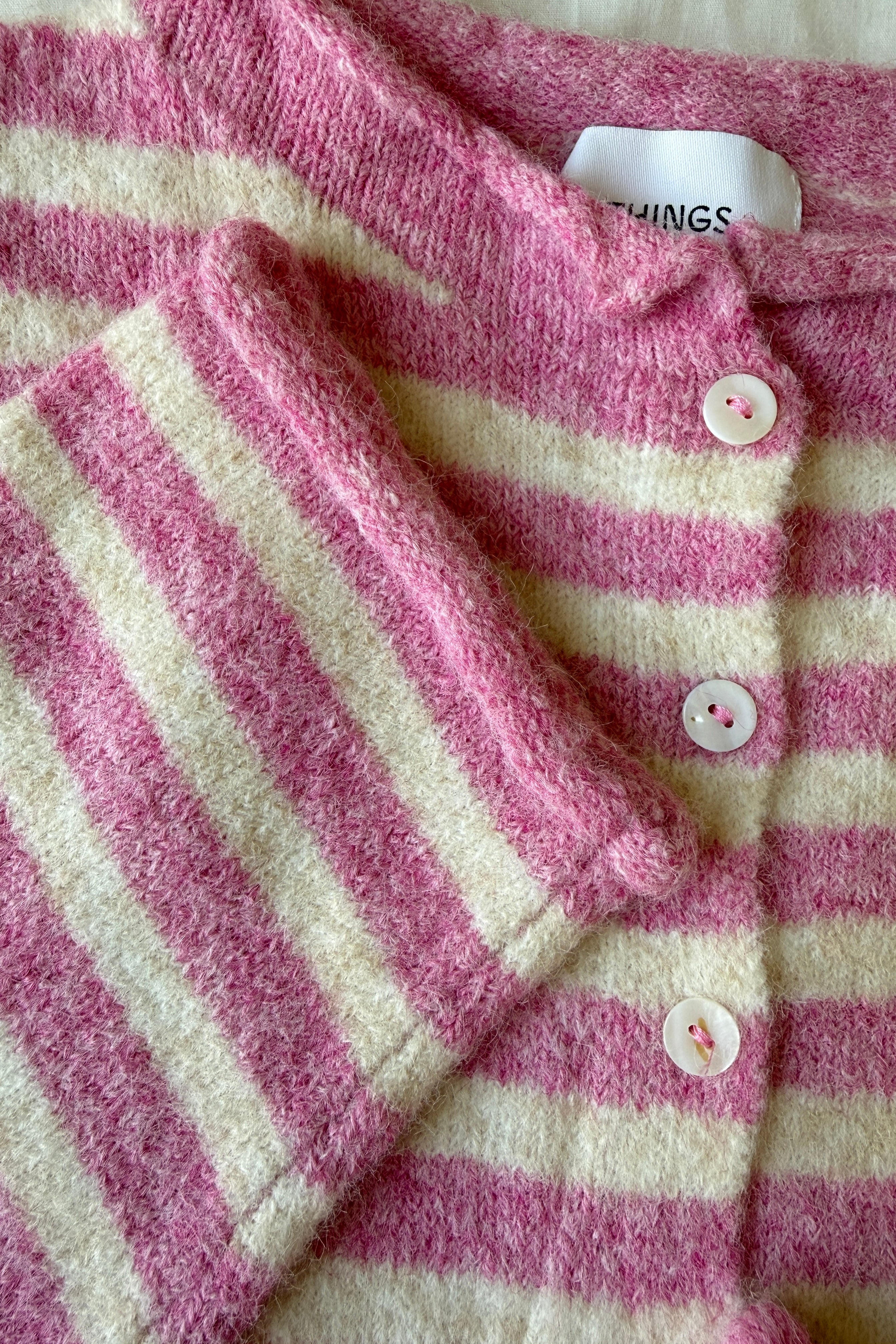 Close-up of the Hailey Button Down Cardigan in Striped Bubblegum showing the soft knit texture, buttons, and pink stripe detail