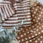 Hailey Button Down Cardigan in Ivory Brown Stripe styled in a flatlay with a polka dot skirt and gold accessories, cozy everyday outfit idea