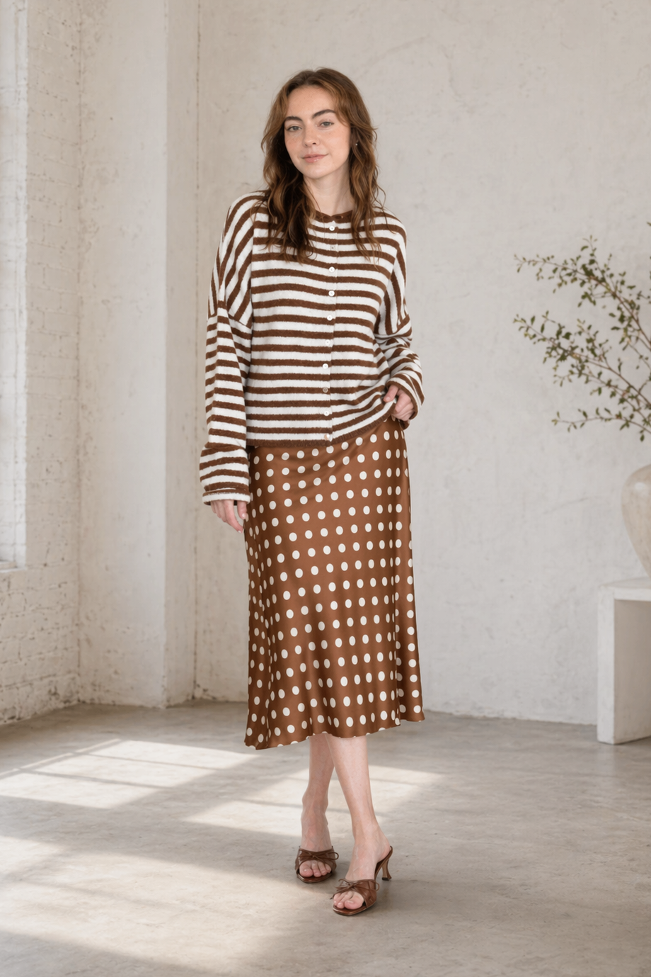Woman wearing the Hailey Button Down Cardigan in Ivory Brown Stripe with a polka dot skirt, styled as an easy everyday outfit