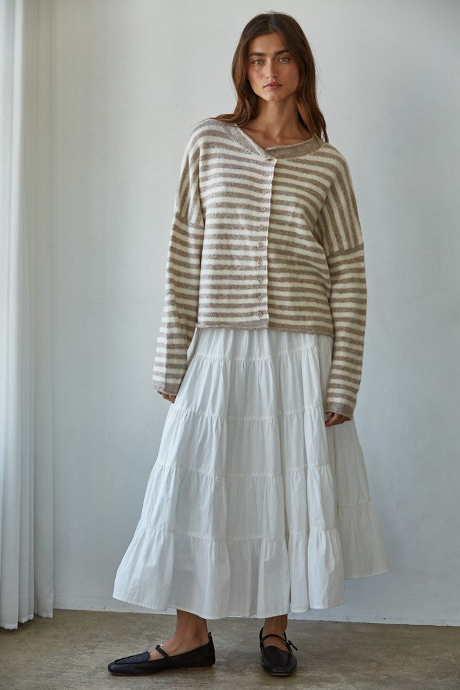 Woman wearing a striped Hailey Button down Cardigan and white skirt against a plain background