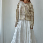 Woman wearing a striped Hailey Button down Cardigan and white skirt against a plain background