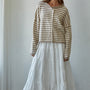Woman wearing a striped Hailey Button down Cardigan and white skirt against a plain background