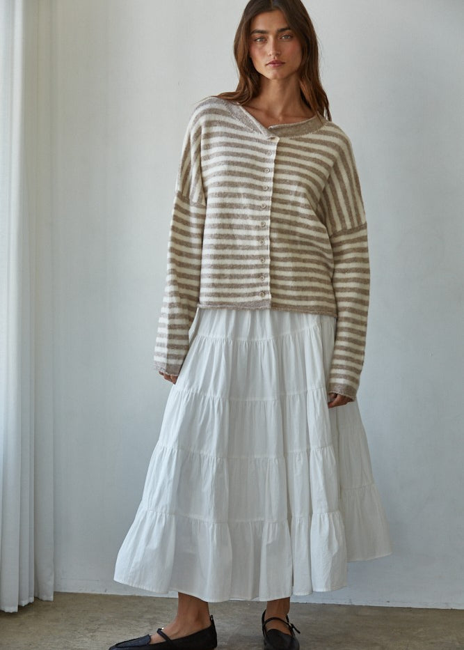 Woman wearing a striped Hailey Button down Cardigan and white skirt against a plain background