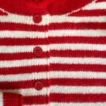 Red and white striped cardigan with buttons on a textured surface