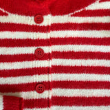 Red and white striped cardigan with buttons on a textured surface