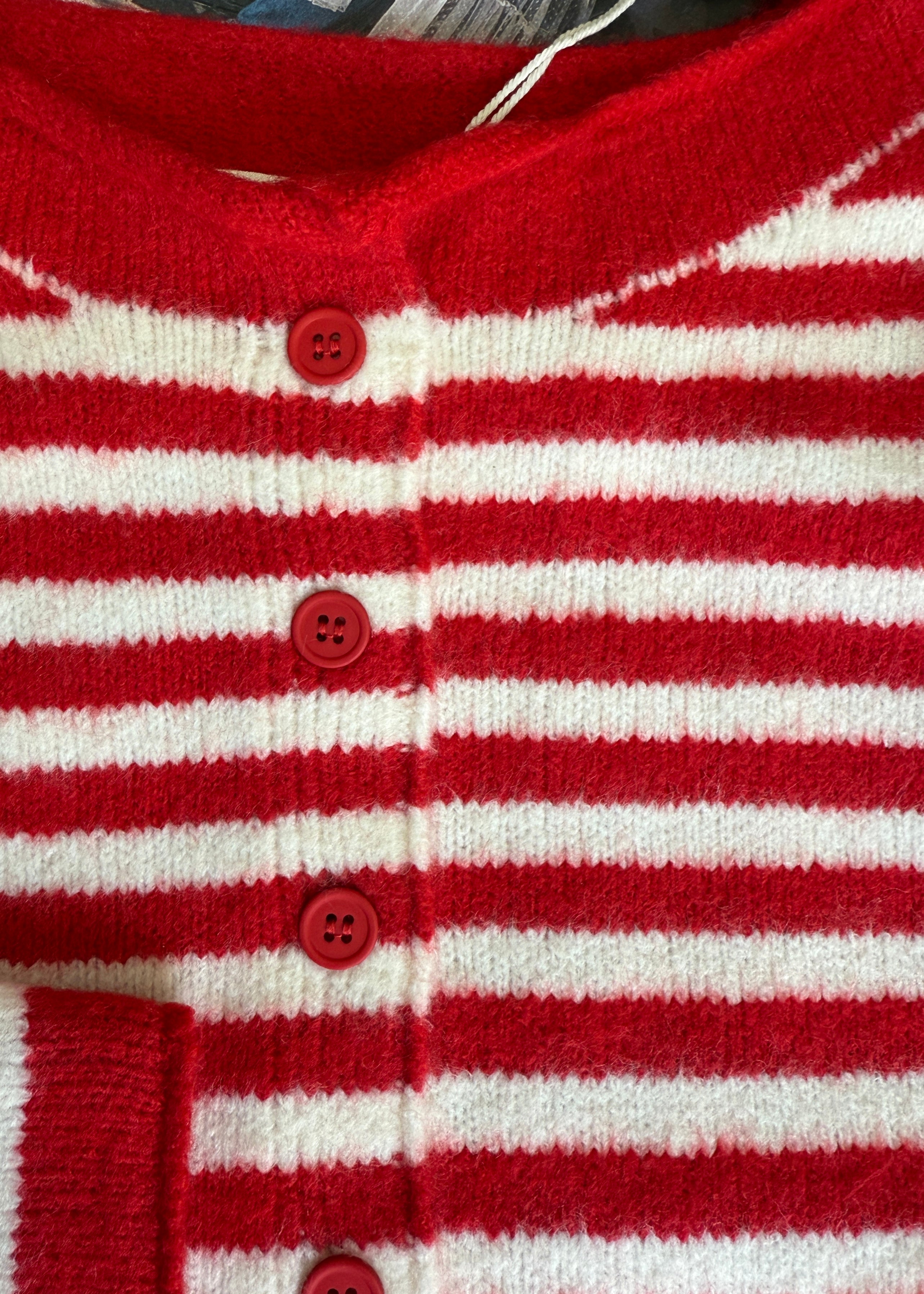 Red and white striped cardigan with buttons on a textured surface