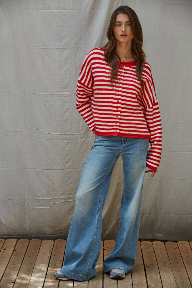 Full-body view of the Kelsey Cardigan in red and ivory styled with denim