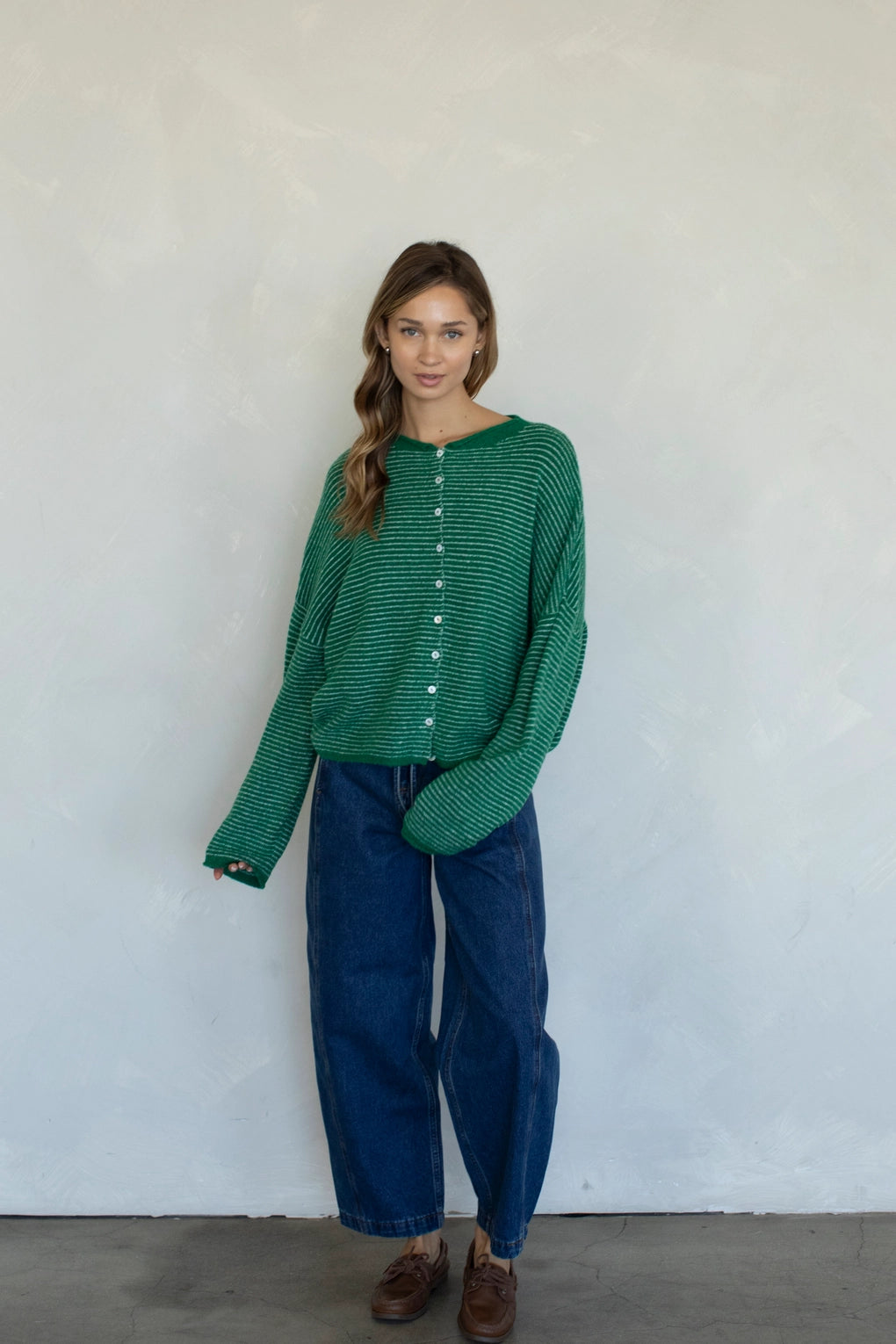 Woman wearing kelly green pin striped Hailey cardigan styled with casual outfit and relaxed fit