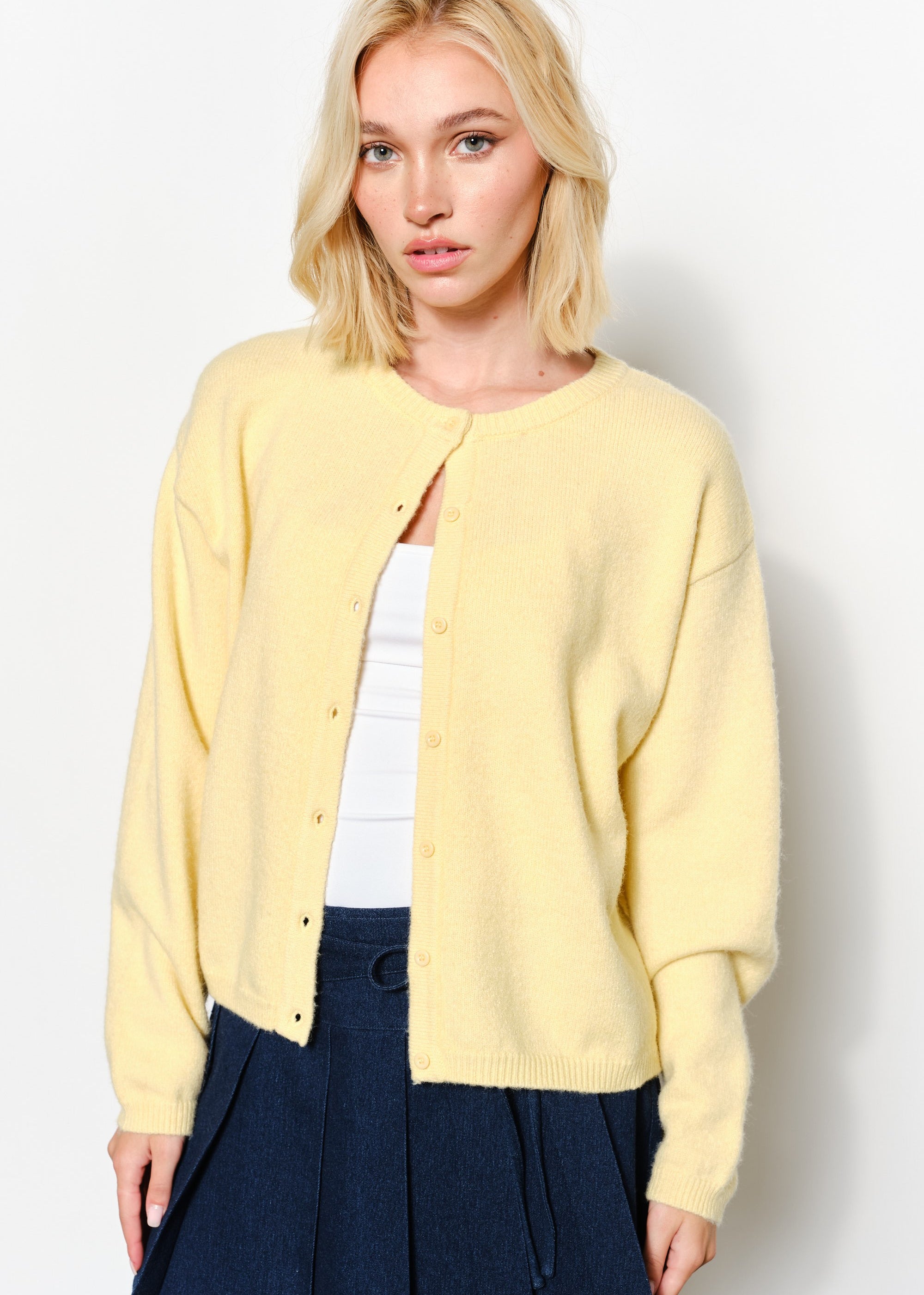 Close-up of the Harper Round-Neck Relaxed Cardigan in butter yellow showing button details and soft knit texture.