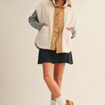 Full-body side view of model wearing the ecru snap vest, showing length and layering fit