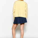 Back of the Harper Round-Neck Relaxed Cardigan in butter yellow — relaxed knit texture with ribbed cuffs and hem.