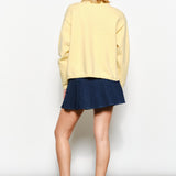 Back of the Harper Round-Neck Relaxed Cardigan in butter yellow — relaxed knit texture with ribbed cuffs and hem.