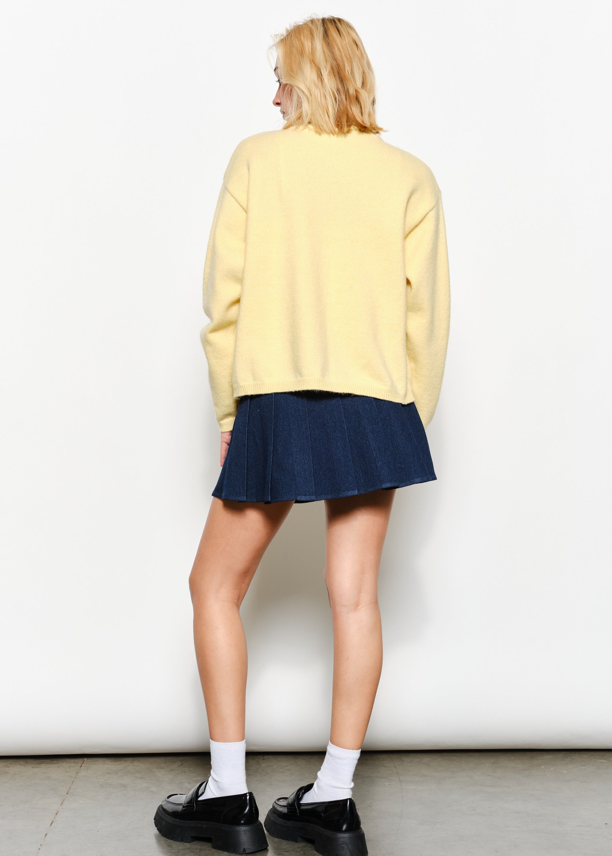 Back of the Harper Round-Neck Relaxed Cardigan in butter yellow — relaxed knit texture with ribbed cuffs and hem.