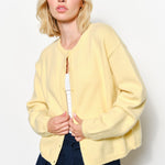 model is wearing  the Harper Round-Neck Relaxed Cardigan in butter yellow.