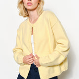 model is wearing  the Harper Round-Neck Relaxed Cardigan in butter yellow.
