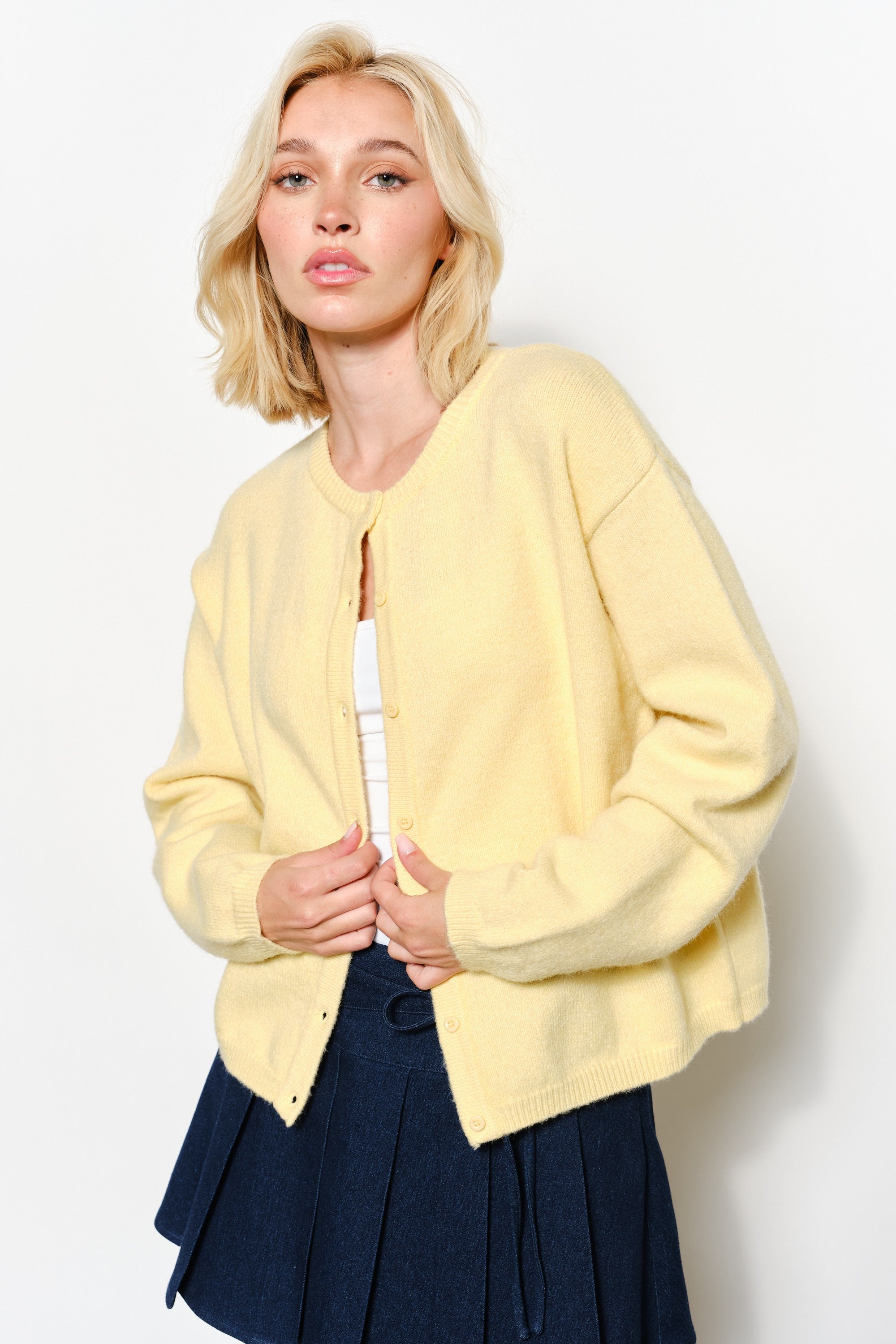 model is wearing  the Harper Round-Neck Relaxed Cardigan in butter yellow.
