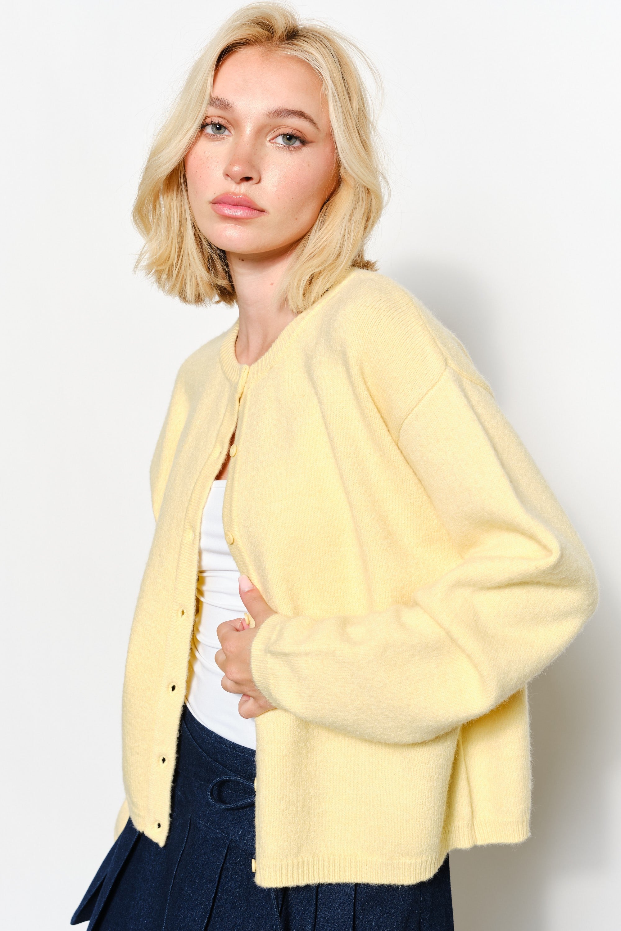 Side view of the Harper Round-Neck Relaxed Cardigan in butter yellow — soft, cozy knit with slightly oversized silhouette.