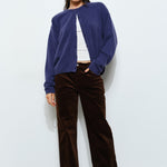 Woman sitting while wearing the Harper Round-Neck Relaxed Cardigan in navy — casual, cozy women’s knit cardigan look.