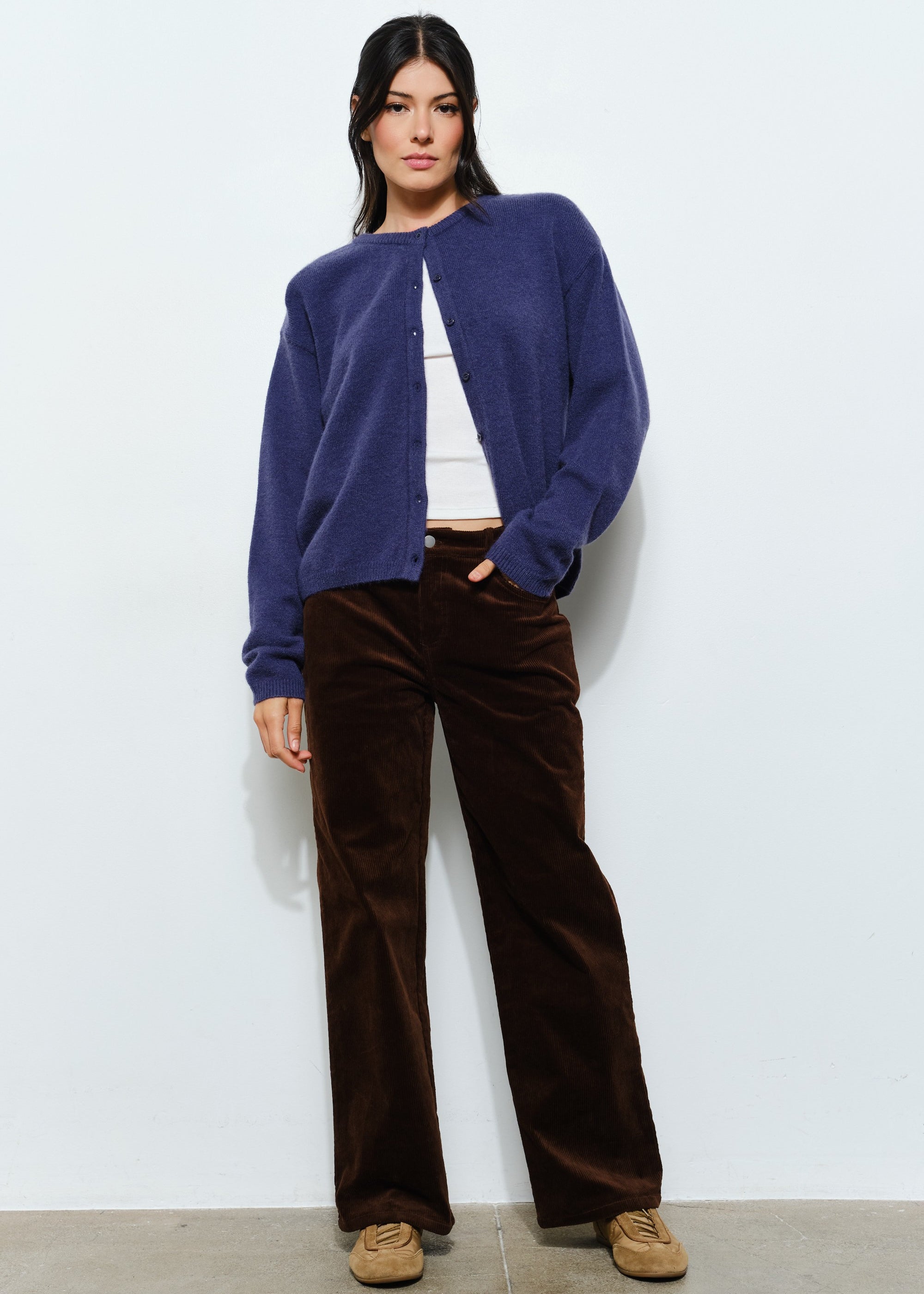 Woman sitting while wearing the Harper Round-Neck Relaxed Cardigan in navy — casual, cozy women’s knit cardigan look.