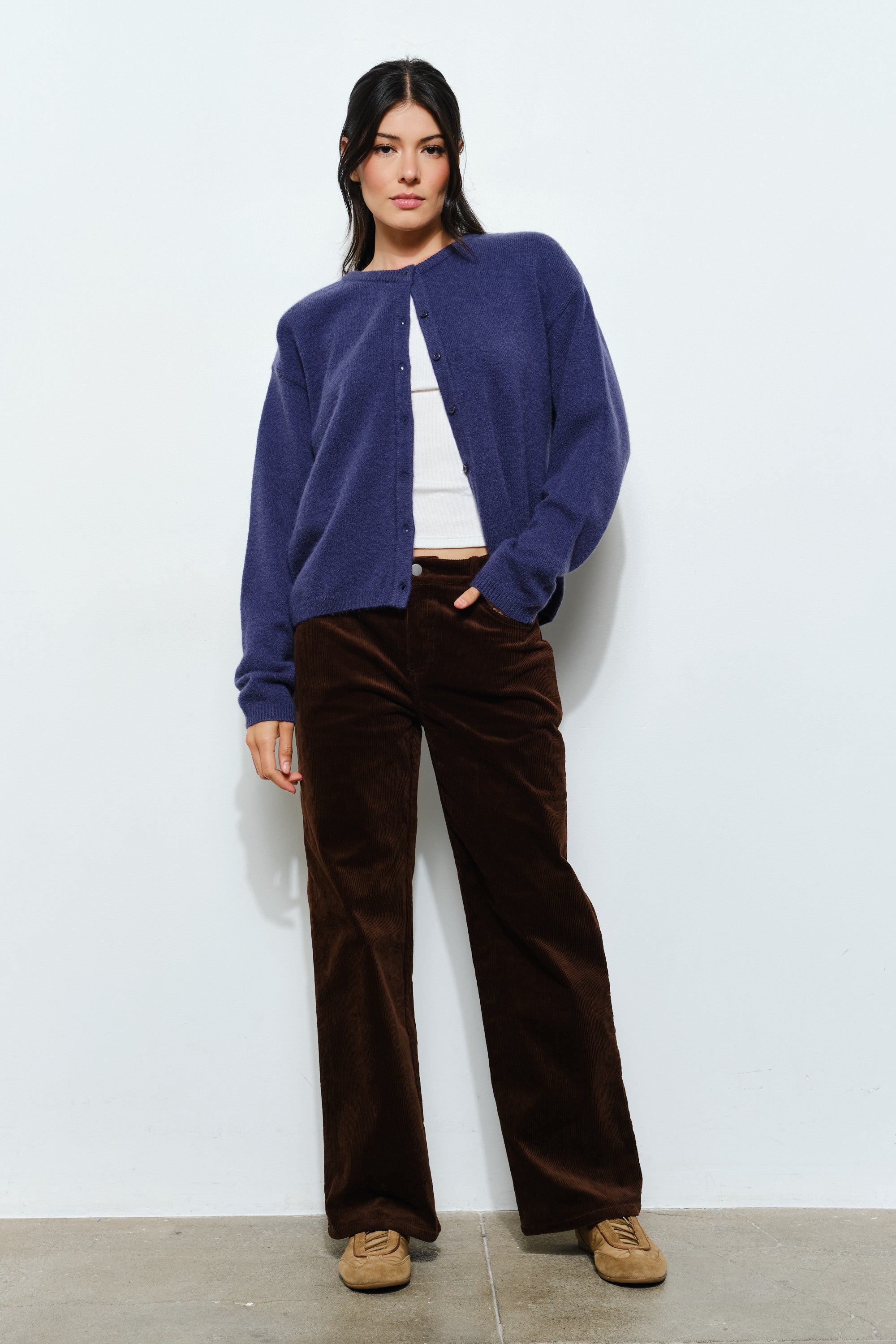 Woman sitting while wearing the Harper Round-Neck Relaxed Cardigan in navy — casual, cozy women’s knit cardigan look.