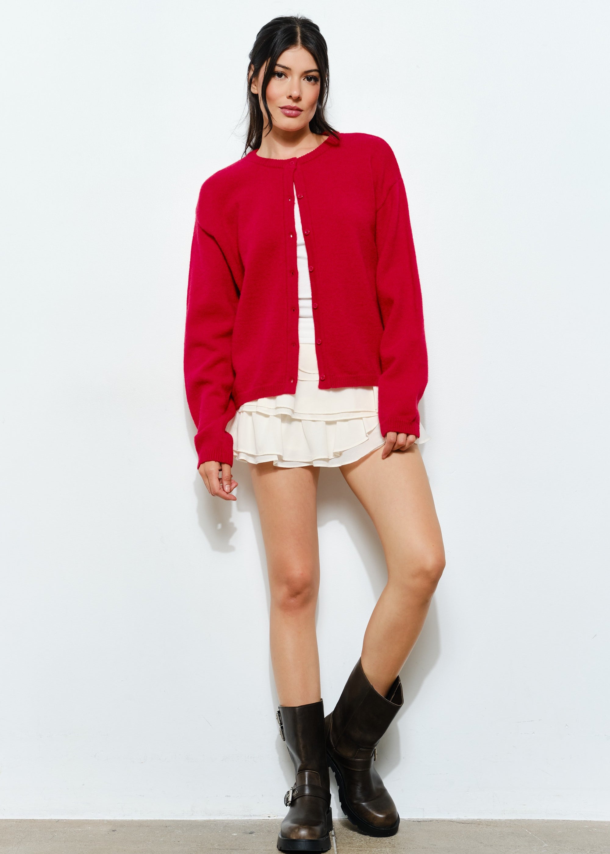 Woman wearing the Harper Round-Neck Relaxed Cardigan in red while seated — cozy and stylish women’s outfit.