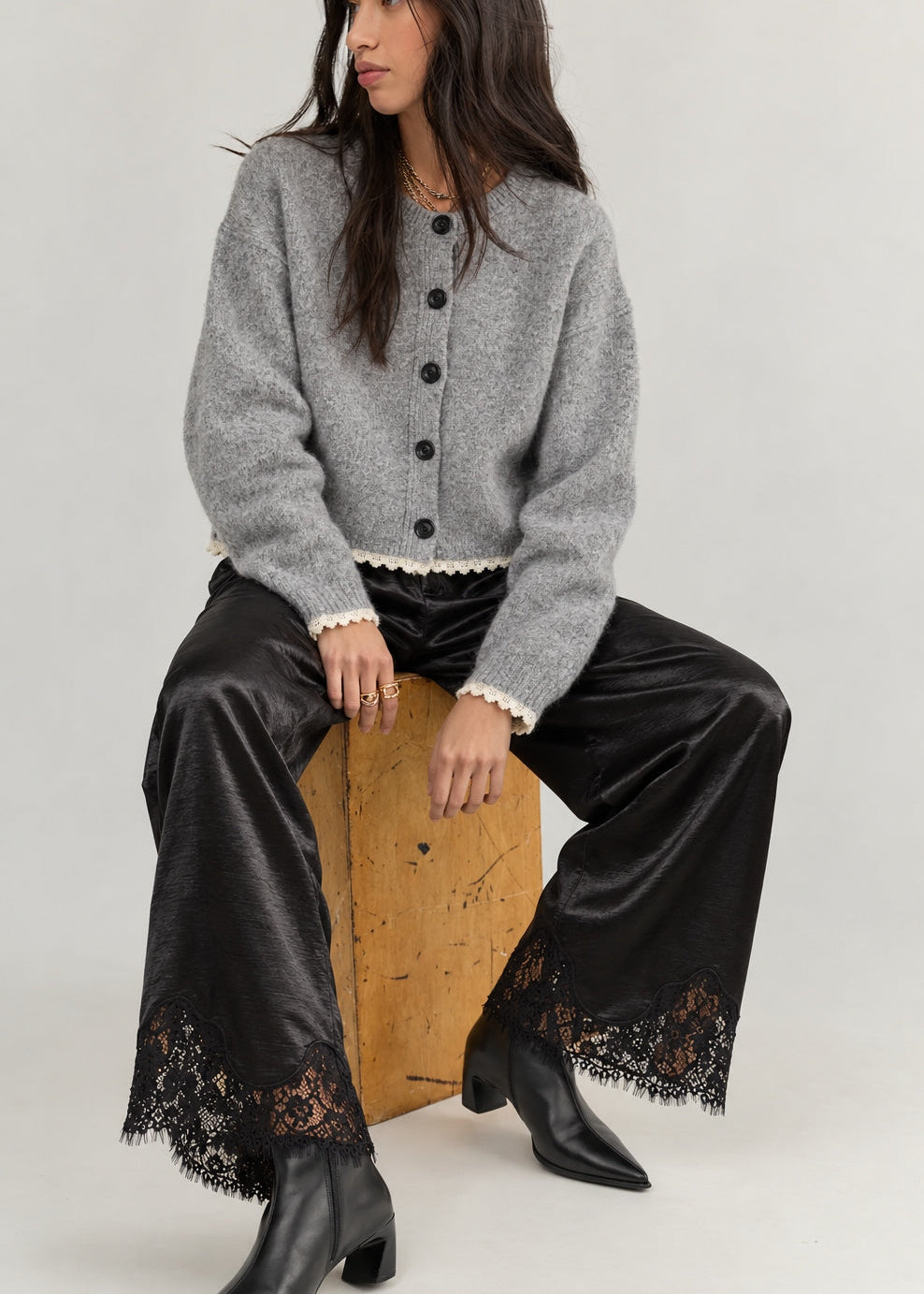 Model wearing Heirloom black satin lace wide-leg pants with a gray cardigan.
