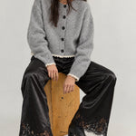 Model wearing Heirloom black satin lace wide-leg pants with a gray cardigan.