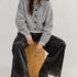 Model wearing Heirloom black satin lace wide-leg pants with a gray cardigan.