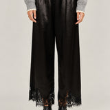  Heirloom black satin pants showing the wide cut and delicate lace hems.