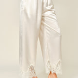 Side view of champagne satin wide-leg pants with soft drape and lace trim hem