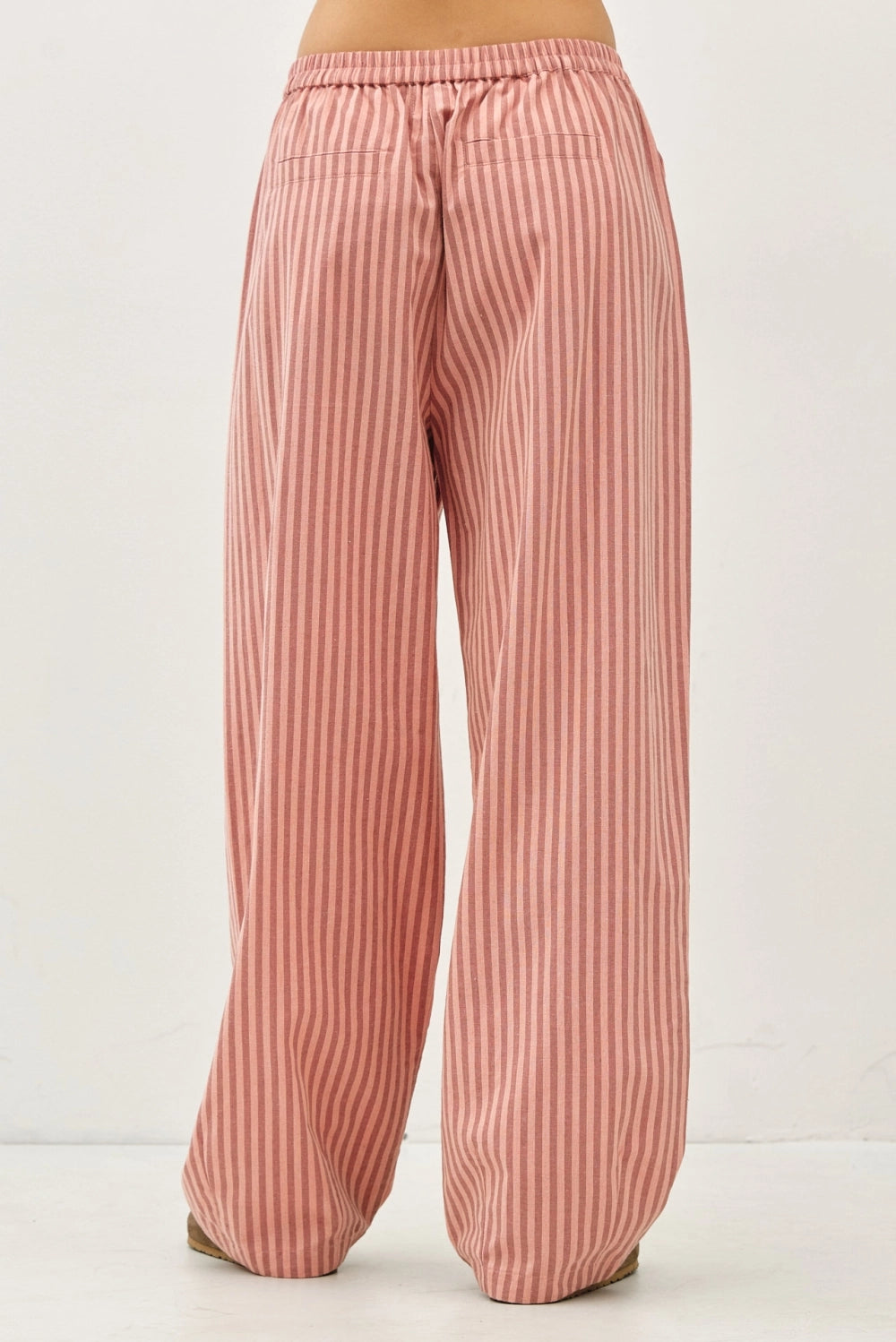 Back view of the Irene Striped Wide Leg Pants in Blush showing the relaxed fit, back pockets, and breathable striped fabric.