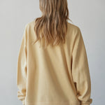 Back view of the Jetset butter yellow crewneck sweatshirt with long sleeves and a white layered hem.