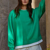 Front view of the Jetset varsity green layered crewneck sweatshirt with white contrast trim at the neckline and hem.