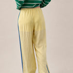 Back view of butter yellow Landon Track Pants showing the blue stripe detail and relaxed pull-on fit.