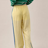 Back view of butter yellow Landon Track Pants showing the blue stripe detail and relaxed pull-on fit.