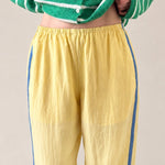 close up photo of  butter yellow Landon Track Pants showing the blue stripe detail and relaxed pull-on fit.