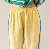 close up photo of  butter yellow Landon Track Pants showing the blue stripe detail and relaxed pull-on fit.