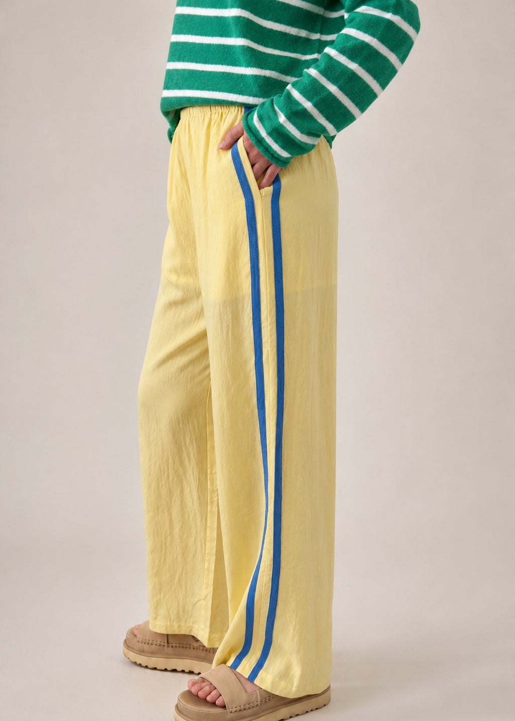 Side view of butter yellow Landon Track Pants showing the blue stripe detail and relaxed pull-on fit.