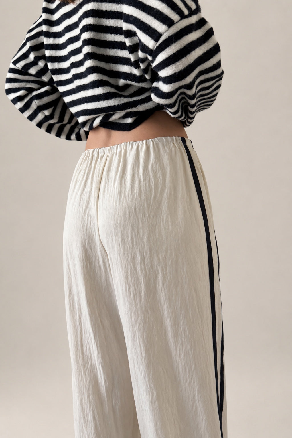 Close up back view of ivory Landon Side Stripe Track Pants showing the contrast blue stripe and relaxed pull-on fit.