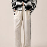 Landon Side Stripe Track Pants in ivory with relaxed wide leg fit, elastic waist, and blue side stripe detail - front view