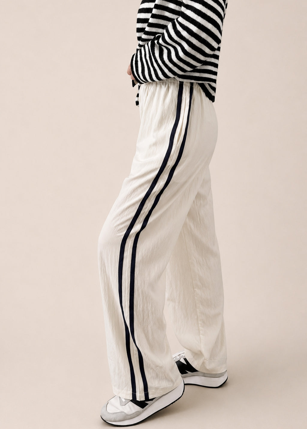 Side view of ivory Landon Side Stripe Track Pants showing the contrast blue stripe and relaxed pull-on fit.