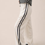 Side view of ivory Landon Side Stripe Track Pants showing the contrast blue stripe and relaxed pull-on fit.