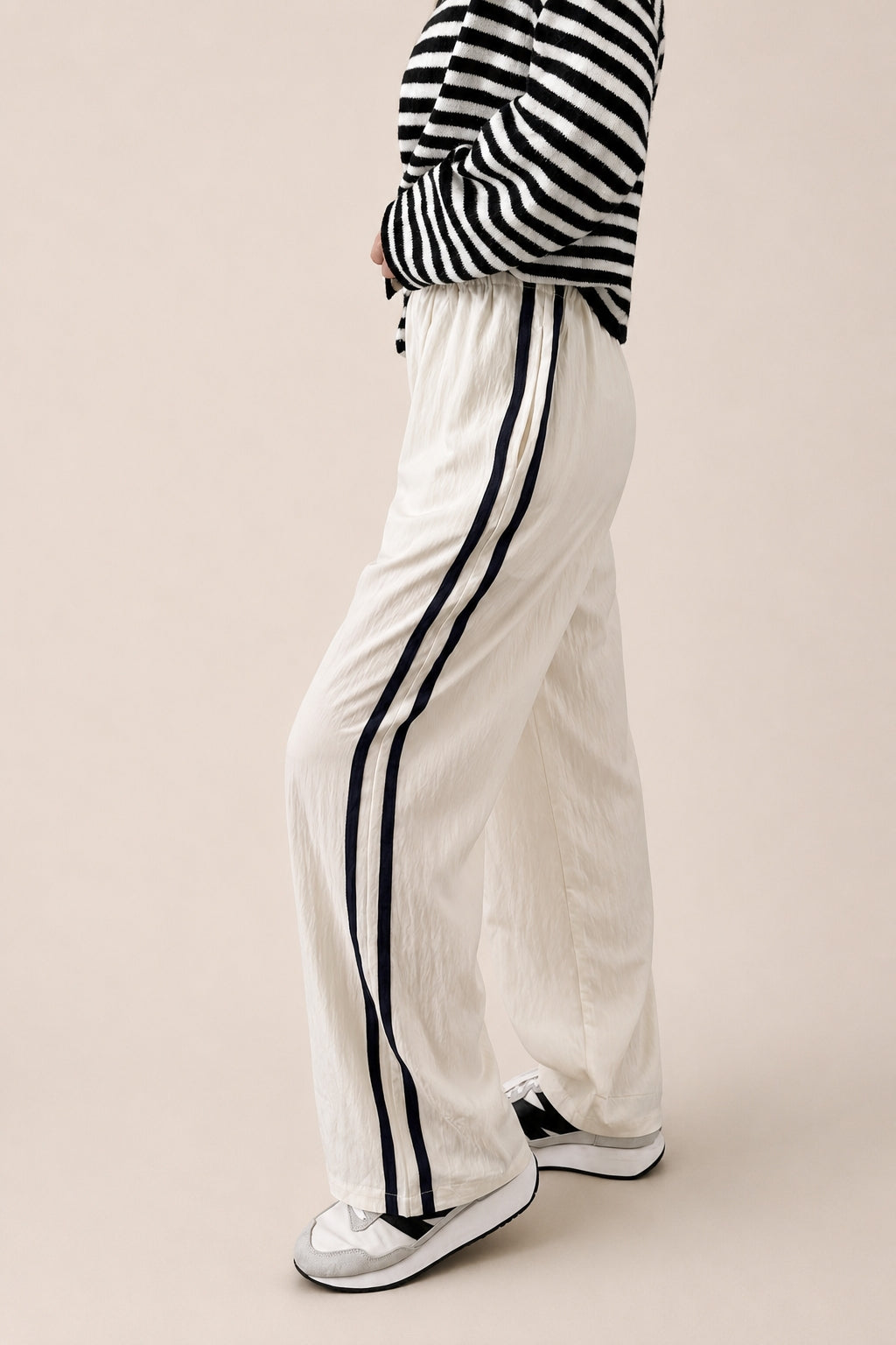 Side view of ivory Landon Side Stripe Track Pants showing the contrast blue stripe and relaxed pull-on fit.
