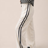 Side view of ivory Landon Side Stripe Track Pants showing the contrast blue stripe and relaxed pull-on fit.
