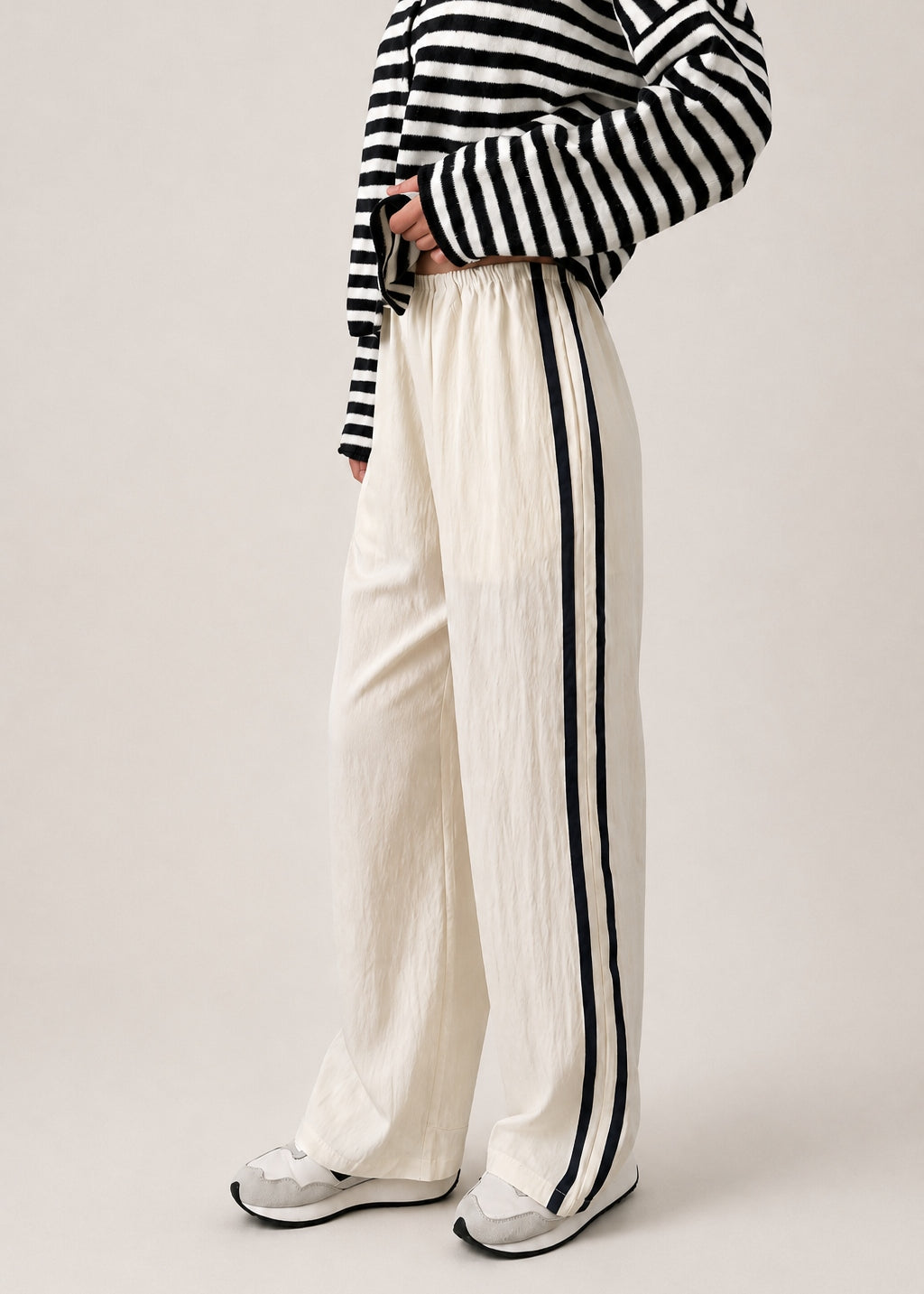 Full length view of the Landon Side Stripe Track Pants in ivory styled for a casual everyday outfit.