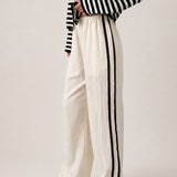 Full length view of the Landon Side Stripe Track Pants in ivory styled for a casual everyday outfit.