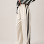 Full length view of the Landon Side Stripe Track Pants in ivory styled for a casual everyday outfit.