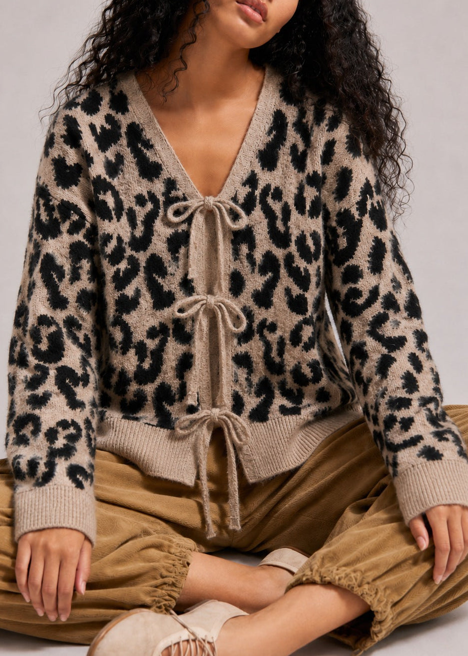 Close-up of the leopard print knit cardigan showing the V-neckline and front bow ties